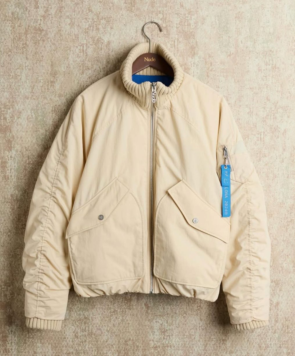 Nude Project — chaqueta beige colgada en una percha